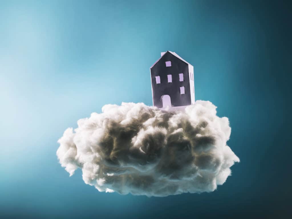 Paper house standing on the cotton cloud. Fairytale, dreaming and imagination concept.
