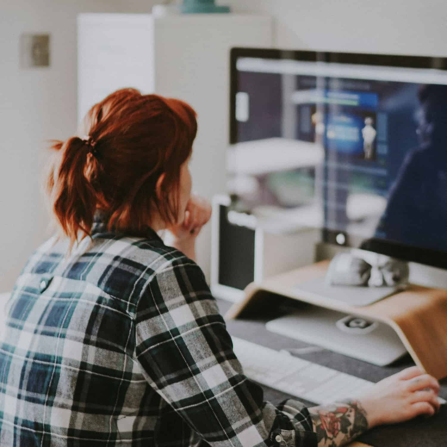 Woman at work, using a computer, looking at the screen